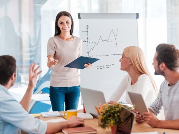Photo of a woman presenting a graph to a meeting